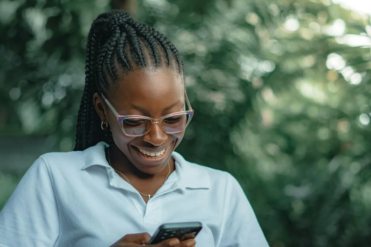 Mulher sorrindo enquanto conversa pelo celular